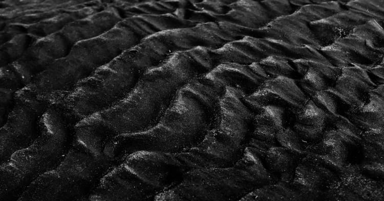 Endless dunes of black sand, like a sea of whispering obsidian