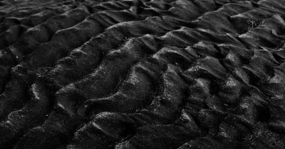 Endless dunes of black sand, like a sea of whispering obsidian